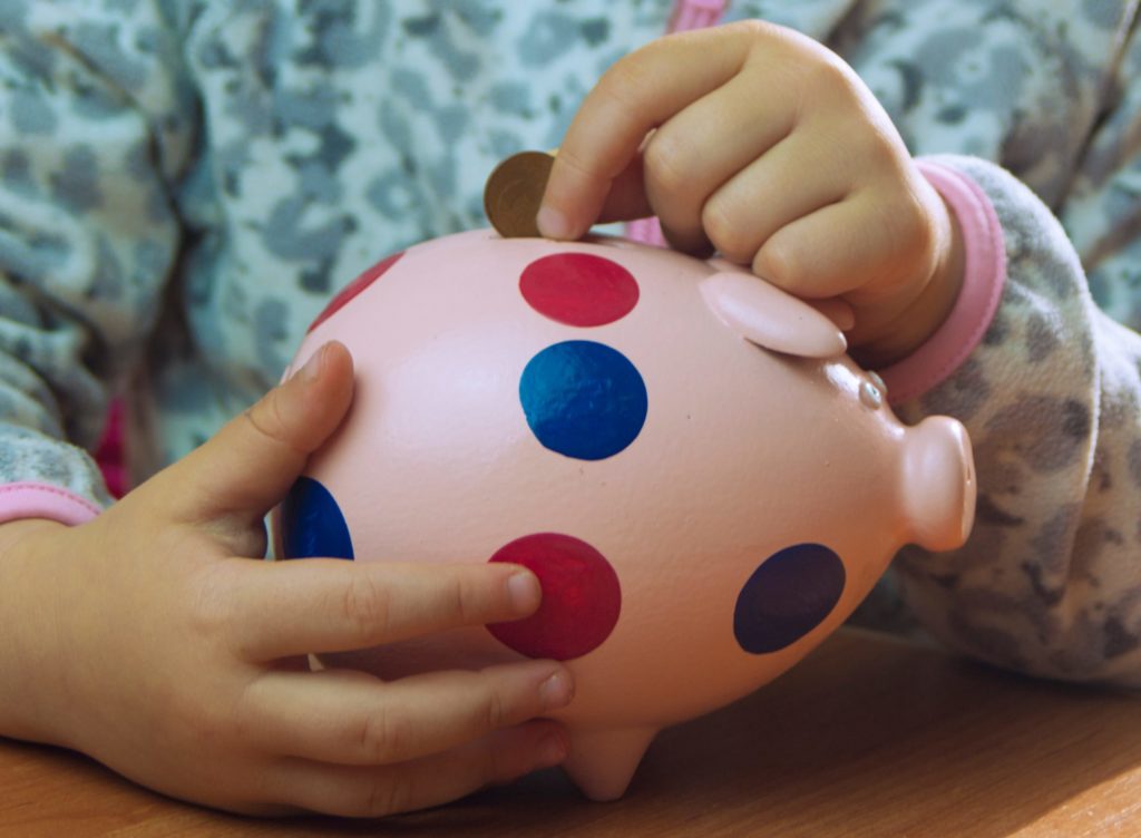 little girl holding piggy Bank, family budget,